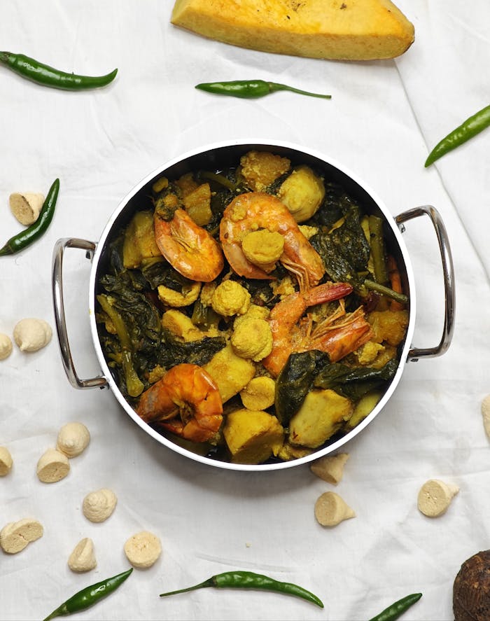 Delicious Bengali prawn curry with veggies in a bowl, showcasing vibrant Indian cuisine.